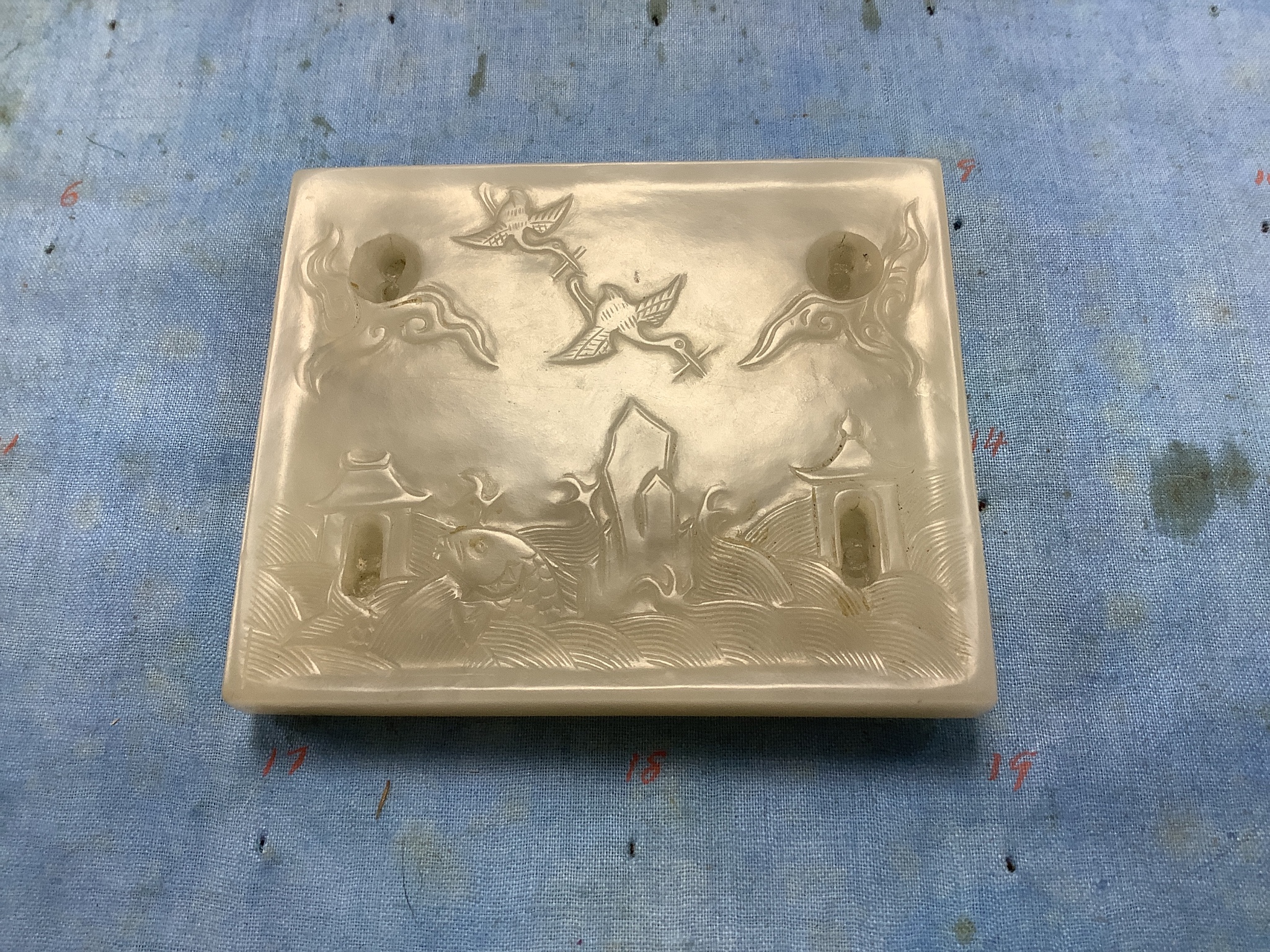 An unusual Chinese white jade plaque, 18th/19th century, 6.7cm x 8.1cm, wood stand